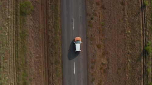 Aerial Birds Eye Overhead Top Down Descending View of Two Colour Car Driving on Straight Road in
