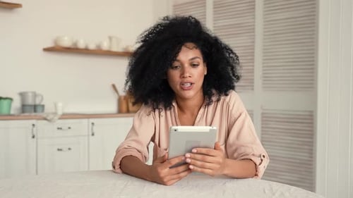 Woman Using Tablet for Video Call in Kitchen