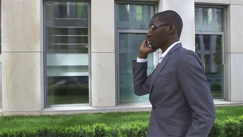 American Businessman Talking on Cell Phone, Standing in Front of His Office. Slow Motion