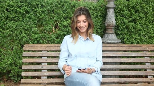 Young Woman Typing on Mobile Phone