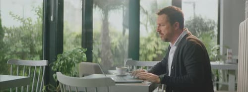 Mann arbeitet am Laptop im leeren Café