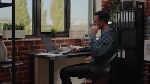 Man Video Conferencing in Office Workplace Setting