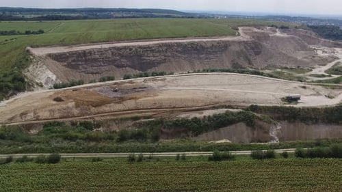Vue aérienne d'une décharge avec une excavatrice en état de marche qui déplace les déchets. 4K