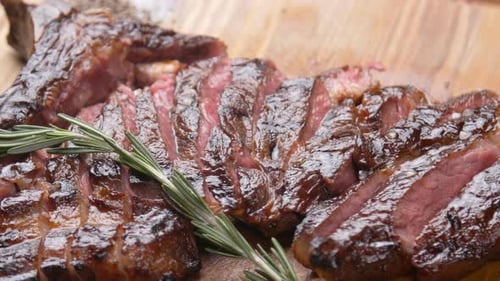 Grilled Steak Slices with Rosemary on Wooden Board