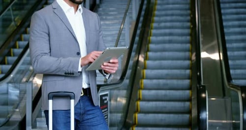 Bearded Man Uses Tablet Near Escalators