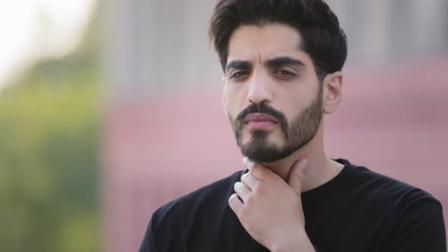 Un jeune homme indien barbu se touchant le cou souffre d'un fort mal de gorge, d'une angine