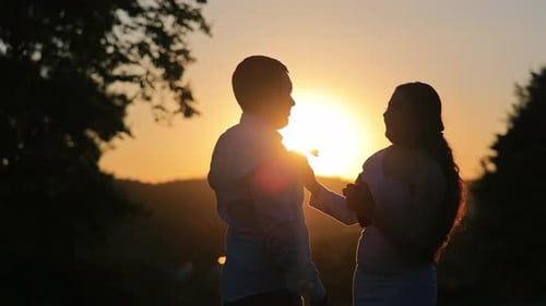 Silhouetted Couple Dancing at Sunset
