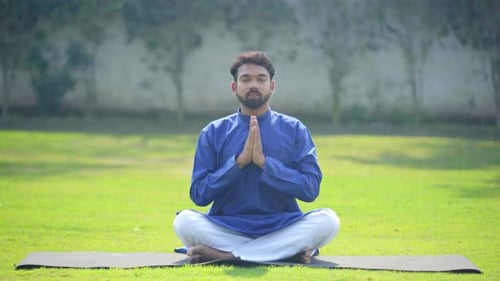 Man Meditates on Yoga Mat Outdoors