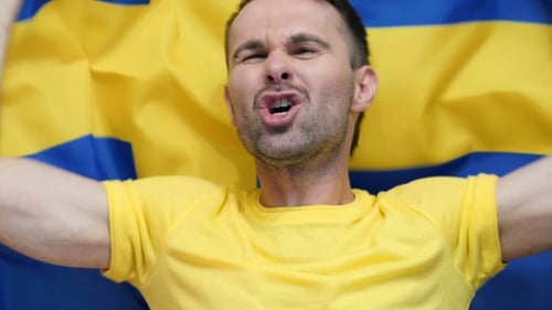 Excited Man Cheers with a National Flag