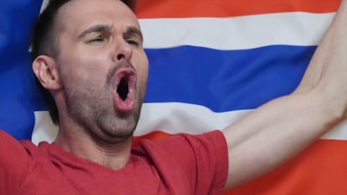 Man Cheering with Flag Raised in Celebration