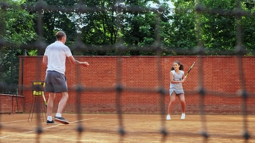Tennis Practice with Man and Teen Girl Outdoors