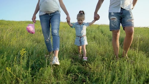 Couple enceinte avec petite fille marchant dans la nature se tenant la main