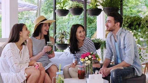 Group of Friends Are Drinking Coctails and Chatting Together at Cafe