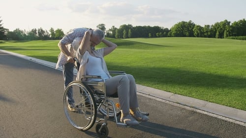 Senior Couple with Wife in Wheelchair on a Walk