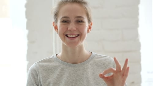 Smiling Woman Giving OK Hand Gesture