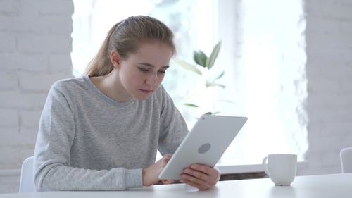 Woman Using Tablet at Home Gets Stressed