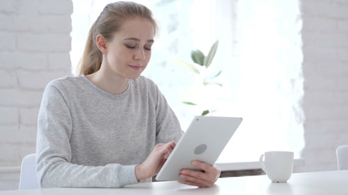 Woman Uses Tablet at Bright White Desk