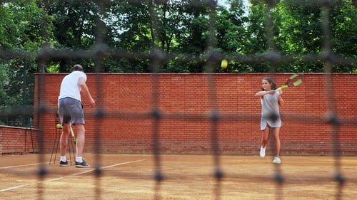 Tennis Coach and Child Practice on Outdoor Court