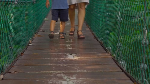 Young Woman and Her Son Walking on the Hanging Suspension Bridge