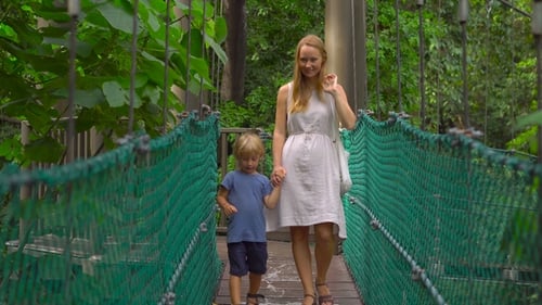 Young Woman and Her Son Walking on the Hanging Suspension Bridge