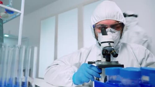 Scientist Adjusting Microscope in Clinical Laboratory