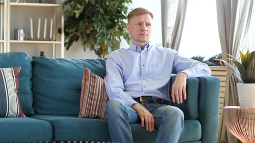 Man Gets Up From Couch in Living Room