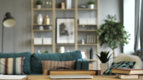 Man Sits at Desk and Opens Laptop