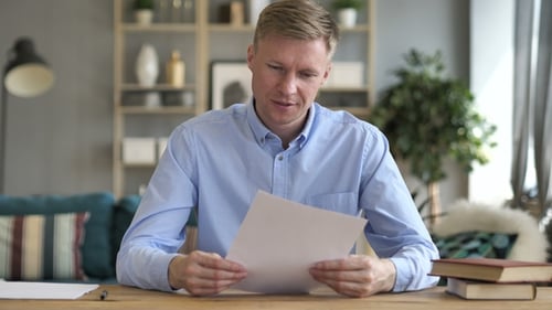 Man Reads Document and Celebrates Success