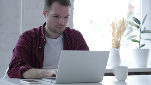 Man Working On Laptop in Office