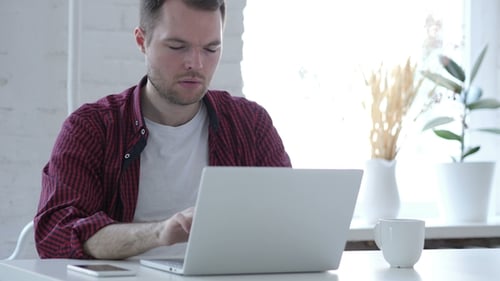 Nachdenklicher Mann denkt und arbeitet am Laptop