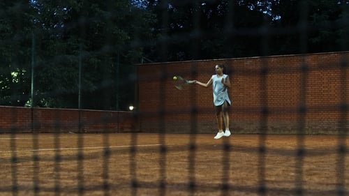 Young Girl Blocking the Ball with the Tennis Racket During the Training
