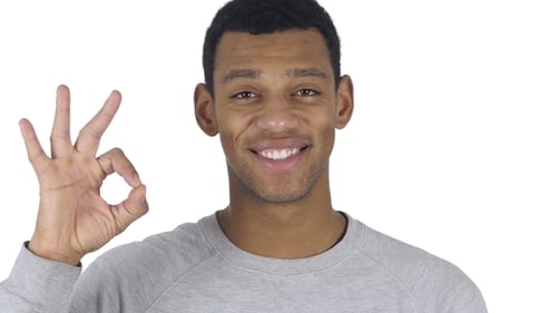 Smiling Man Makes OK Sign on White Background