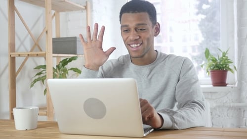 Video Chat By Young Afro-American Man in Office on Laptop