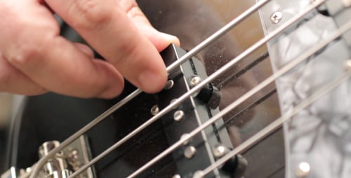 Close Up of Hand Playing Bass Guitar