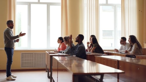Friendly Teacher Is Talking To Students, Smart Mixed Race Man Is Raising Hand and Speaking Sitting