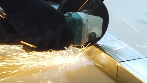 of Sparks From Circular Grinding Machine Cutting Metal Profile in Workshop