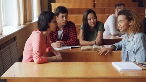 Students Are Discussing Team Project Sitting at Desks in University, Girls and Boys Are Talking