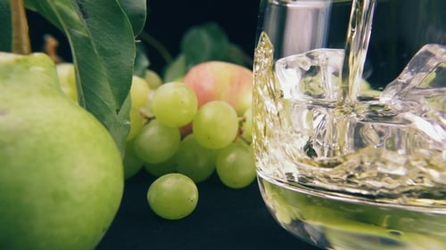 Fruit Display with Refreshing Drink Pouring Into Glass