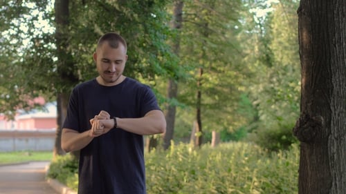 Man Runner with Fitness Tracker in the Park