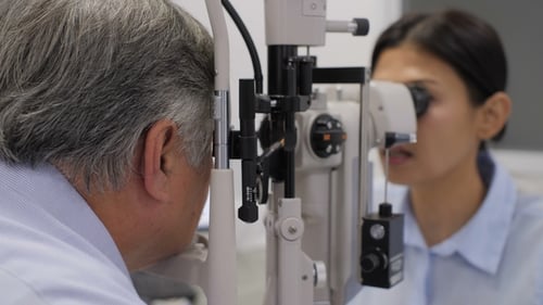 Doctor Checking Senior Patients Eyes.