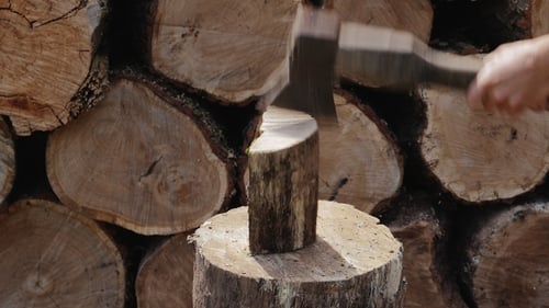 Axe Splitting a Log on a Wooden Stump