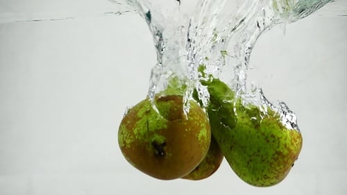 Conference Pears Are Immersed in Water with Bubbles. Pears on White Isolated Background