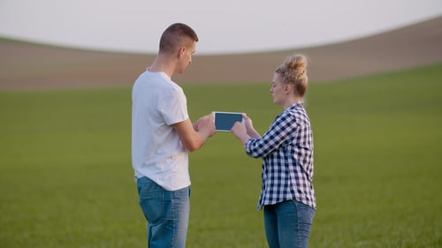 Farmers Discussing While Using Tablet Computer At Farm