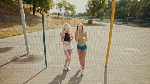 Junge Hipster-Mädchen mit Sonnenbrille haben Spaß daran, im Freien Blasen zu machen