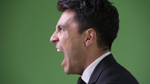 Young Handsome Hispanic Businessman Against Green Background