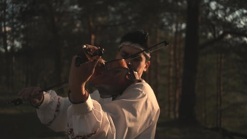 Man Playing the Violin Outdoors in Summer in the Woods Outdoors