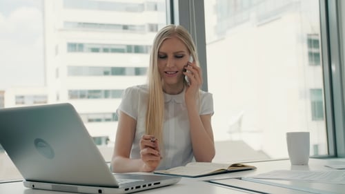 Femme sérieuse travaillant dans la salle de bureau légère. Femme d'affaires moderne élégante avec ordinateur portable et papiers à