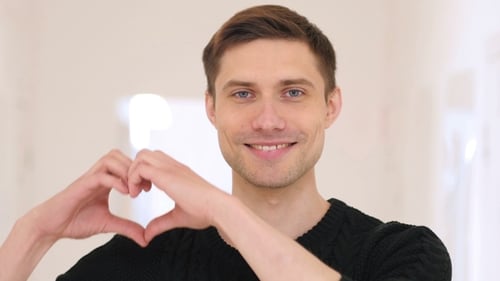 Young Man Making a Heart Shape with Hands