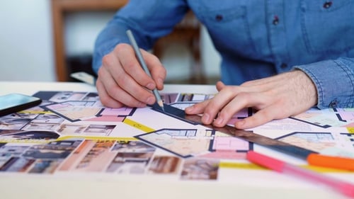 Architect Drawing House Plan at Desk