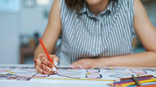 Woman Designing Home Floor Plan with Colored Pencil
